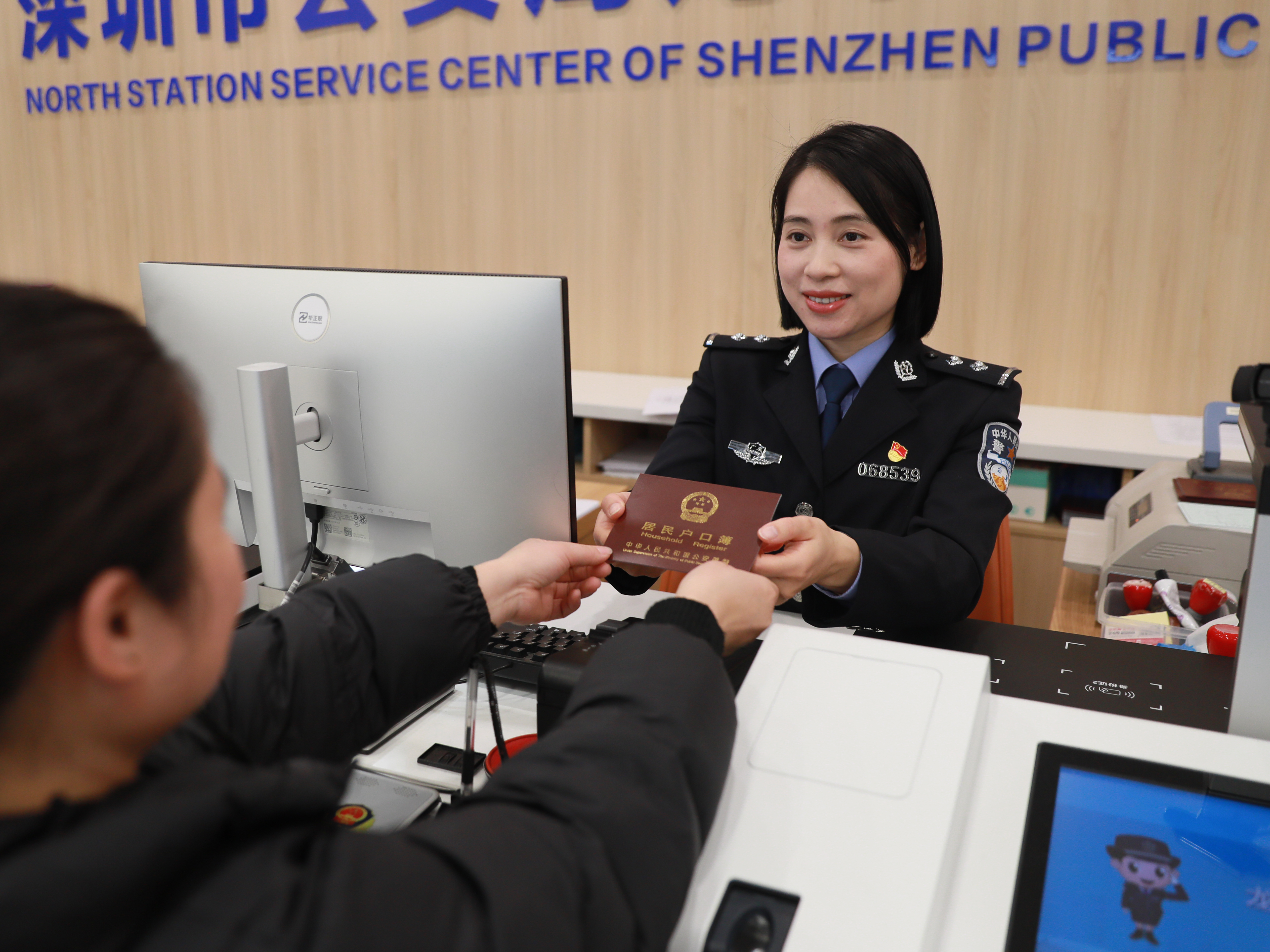 2025年1月14日,北站服务中心民警为群众递上办好的户口本.jpg